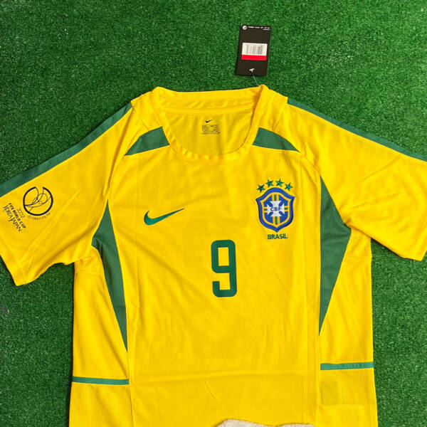 Maillot domicile Brésil 2002, jaune et vert, porté par Ronaldo lors de la victoire en Coupe du Monde.