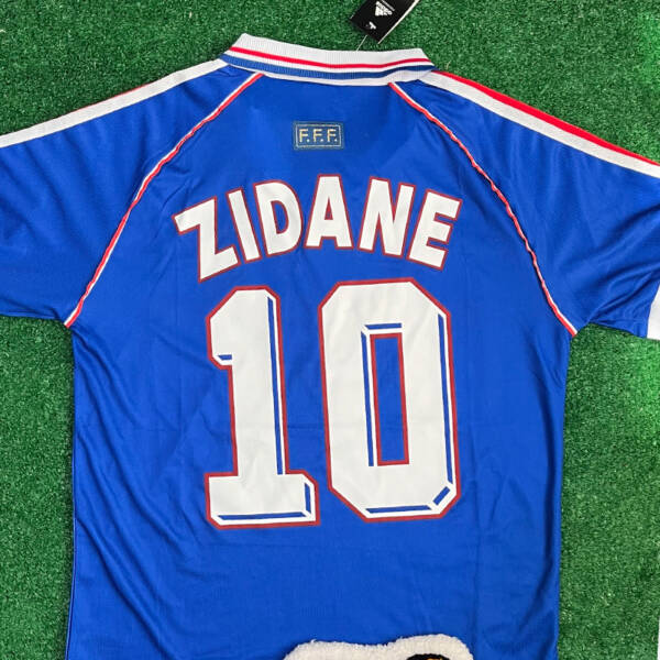 Maillot domicile France 1998, bleu avec bandes blanches et rouges, porté par Zidane.