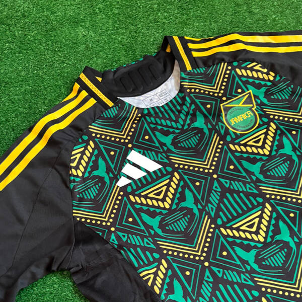 Maillot extérieur Jamaïque 2024, design moderne avec des couleurs noires et dorées.