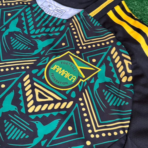 Maillot extérieur Jamaïque 2024, design moderne avec des couleurs noires et dorées.