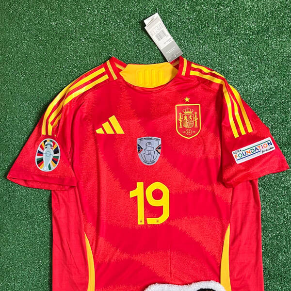 Maillot domicile Espagne 2024, porté par Lamine Yamal, avec des couleurs rouge et or.
