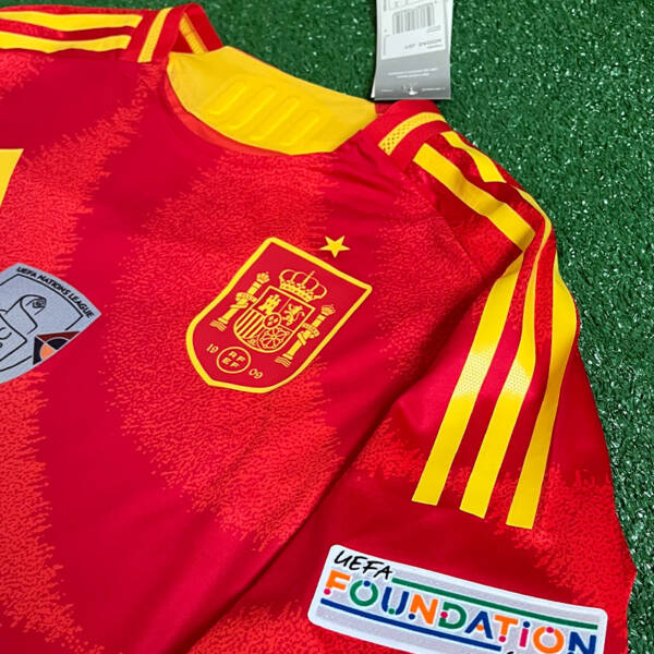 Maillot domicile Espagne 2024, porté par Lamine Yamal, avec des couleurs rouge et or.