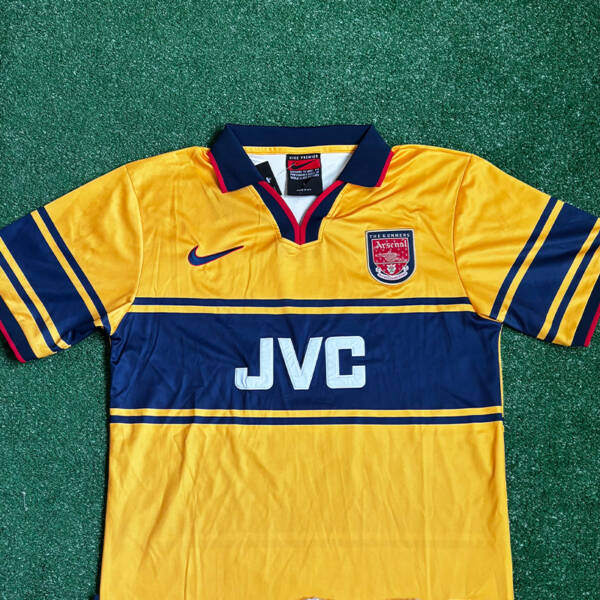 Maillot extérieur Arsenal 1998-1999, jaune avec des touches de bleu porté par Bergkamp.