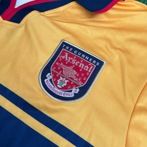 Maillot extérieur Arsenal 1998-1999, jaune avec des touches de bleu porté par Bergkamp.