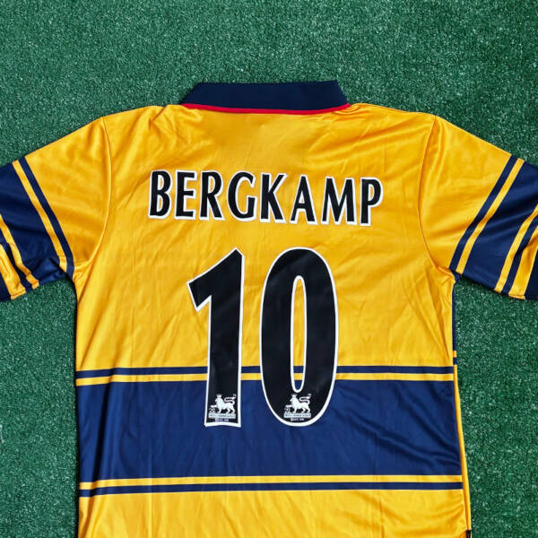 Maillot extérieur Arsenal 1998-1999, jaune avec des touches de bleu porté par Bergkamp.