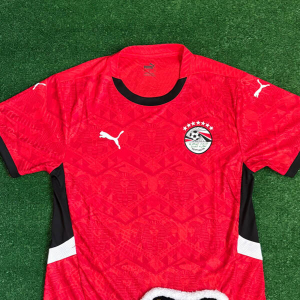 Maillot domicile Égypte 2025, rouge classique avec détails noirs.